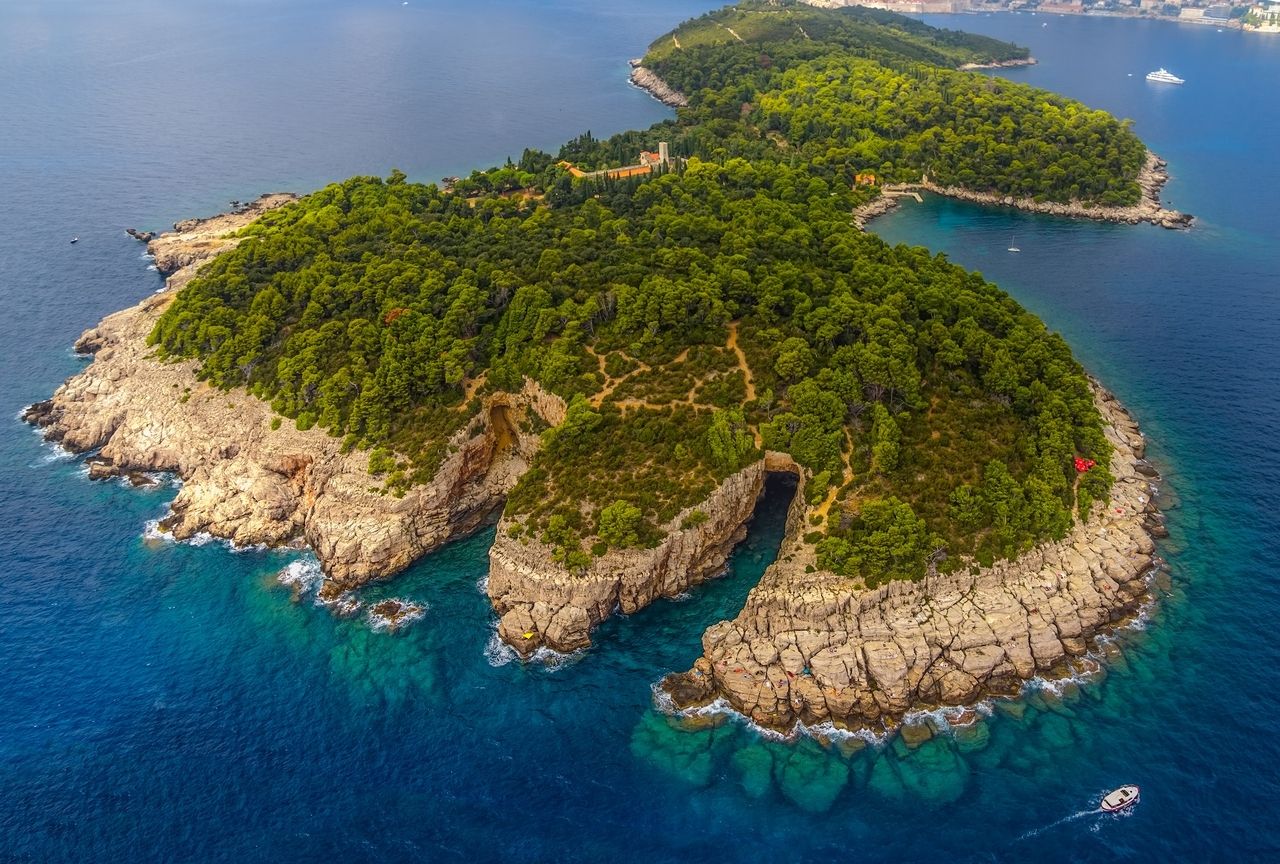 Luftfoto av øya Lokrum foran Dubrovnik, omgitt av klart, blått vann