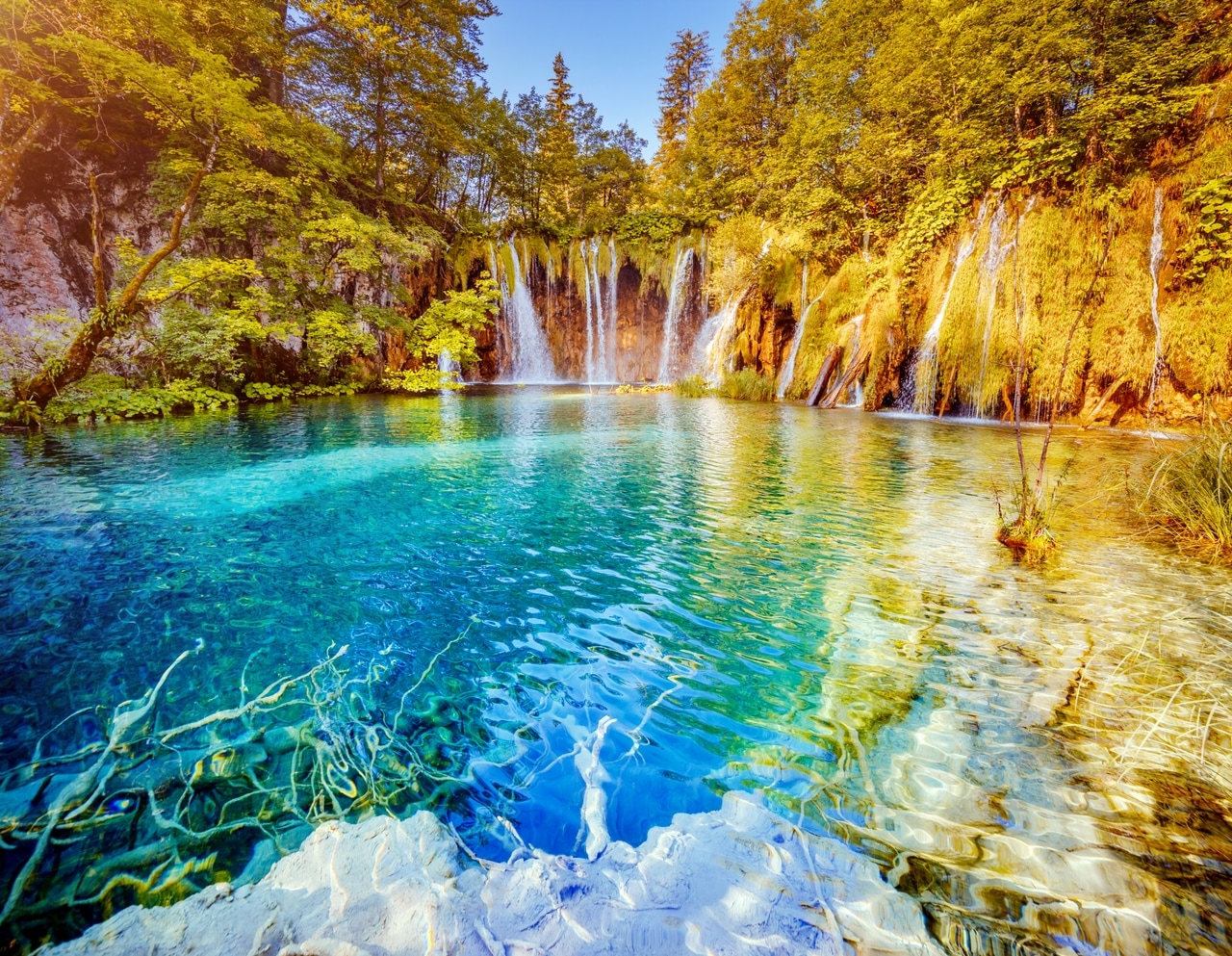 Chutes d'eau pittoresques et eau cristalline dans le parc national des lacs de Plitvice en Croatie, entourés d'une végétation luxuriante. La beauté naturelle et l'eau émeraude font de cet endroit une destination prisée.